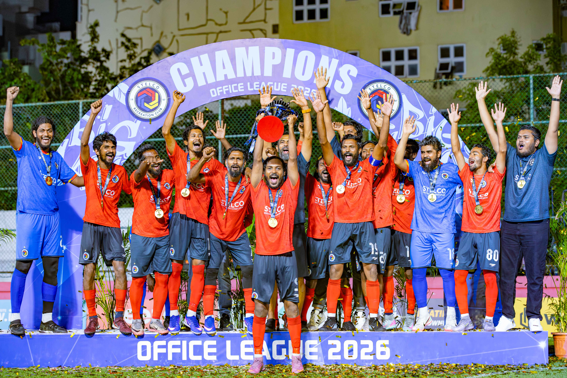 Office League 2026 champions lifting the trophy on the podium